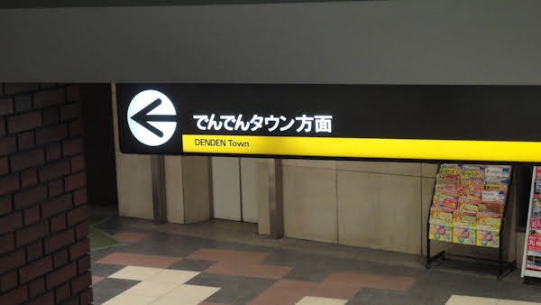 sign in a subway station showing the den den town exit